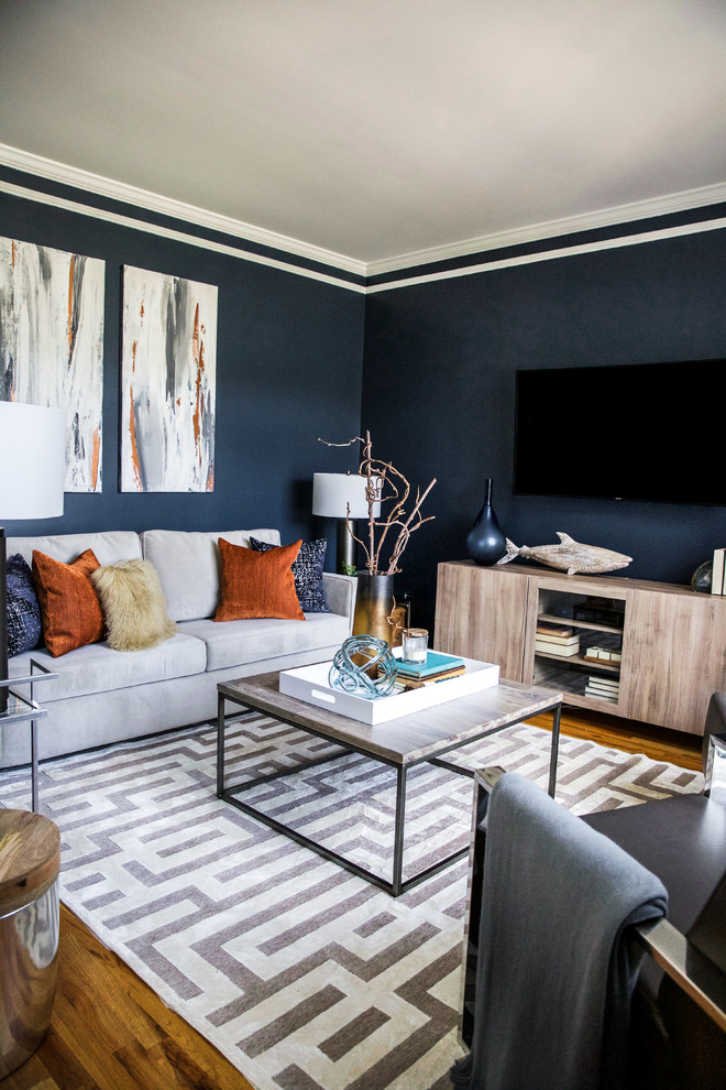 Bild på ett litet funkis separat vardagsrum, med blå väggar, mellanmörkt trägolv, en väggmonterad TV och grått golv