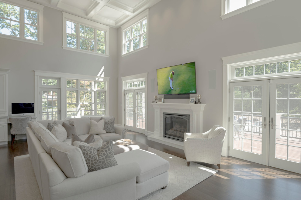 Großes, Offenes Modernes Wohnzimmer mit beiger Wandfarbe, braunem Holzboden, Kamin, Kaminumrandung aus Holz, TV-Wand und braunem Boden in Boston