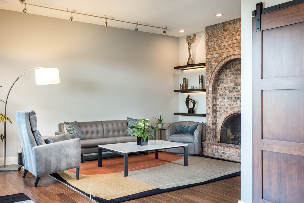 Living room - large formal and open concept medium tone wood floor and brown floor living room idea in Portland with gray walls, a standard fireplace and a brick fireplace