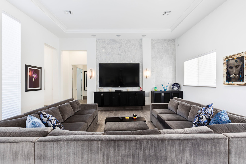 Mittelgroßes, Repräsentatives, Offenes Modernes Wohnzimmer ohne Kamin mit weißer Wandfarbe, hellem Holzboden, TV-Wand und grauem Boden in Orlando