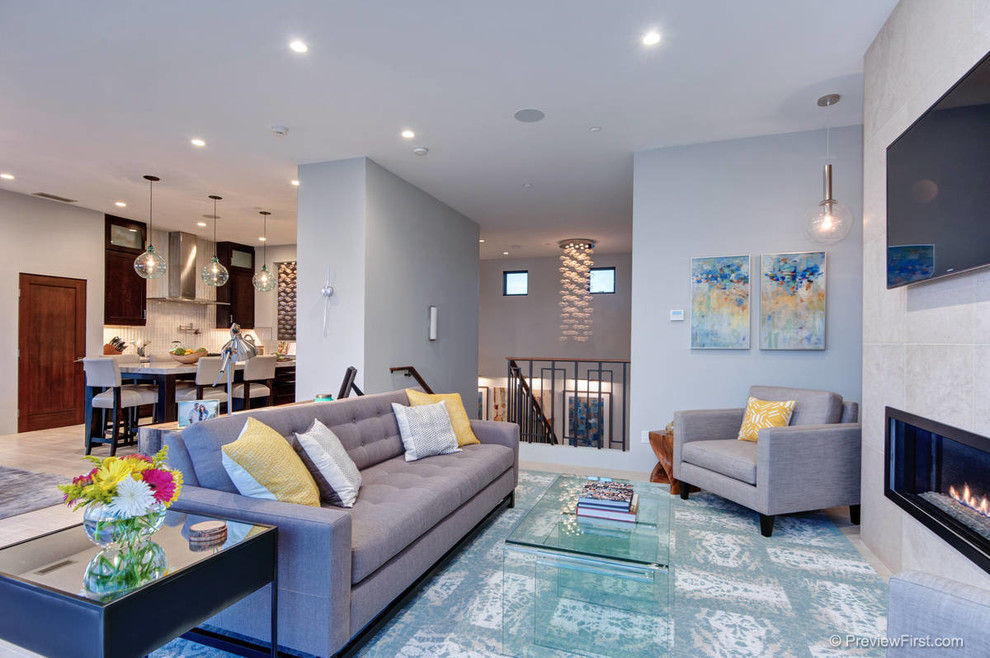 Immagine di un soggiorno minimalista di medie dimensioni e aperto con pareti grigie, cornice del camino in pietra e TV a parete