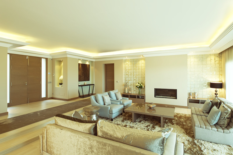 Großes, Repräsentatives, Fernseherloses, Offenes Modernes Wohnzimmer mit beiger Wandfarbe, Gaskamin und verputzter Kaminumrandung in Sonstige