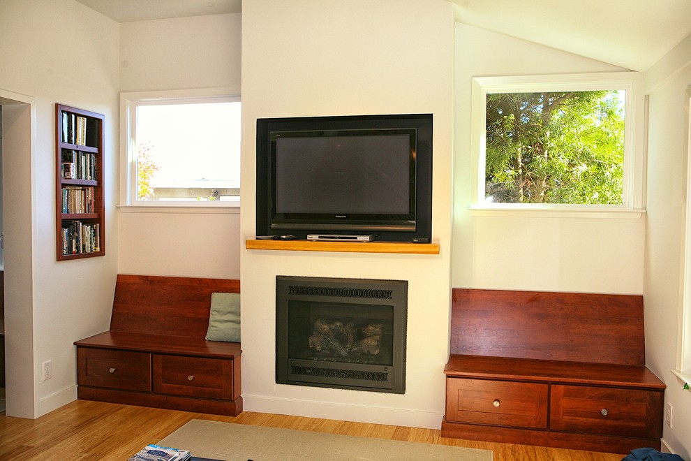 Modern inredning av ett mellanstort allrum med öppen planlösning, med ett bibliotek, vita väggar och en väggmonterad TV