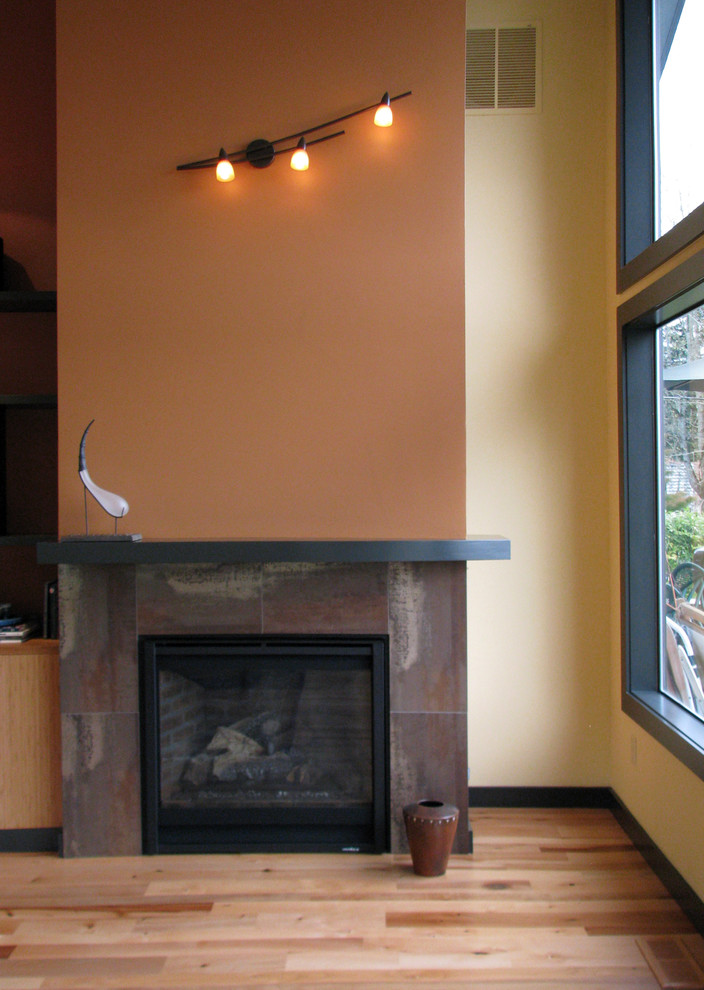 Aménagement d'un salon contemporain ouvert avec un mur rouge, parquet clair, une cheminée standard, un manteau de cheminée en béton, aucun téléviseur et un sol marron.