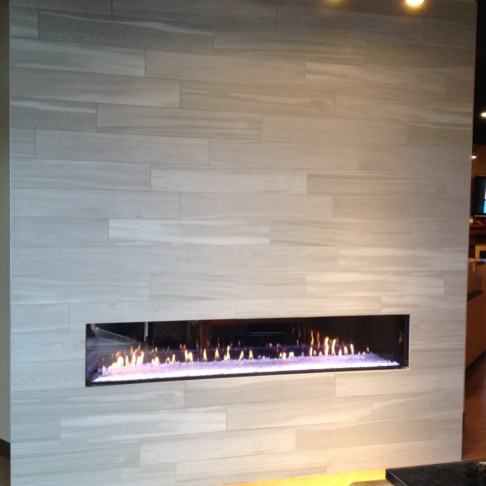 Contemporary living room in Seattle with a ribbon fireplace and a tiled fireplace surround.