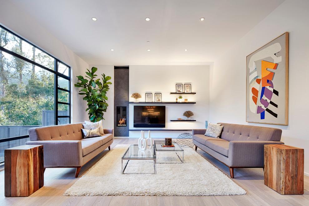 Cette photo montre un salon tendance avec une salle de réception, un mur blanc, parquet clair, une cheminée ribbon et un téléviseur fixé au mur.