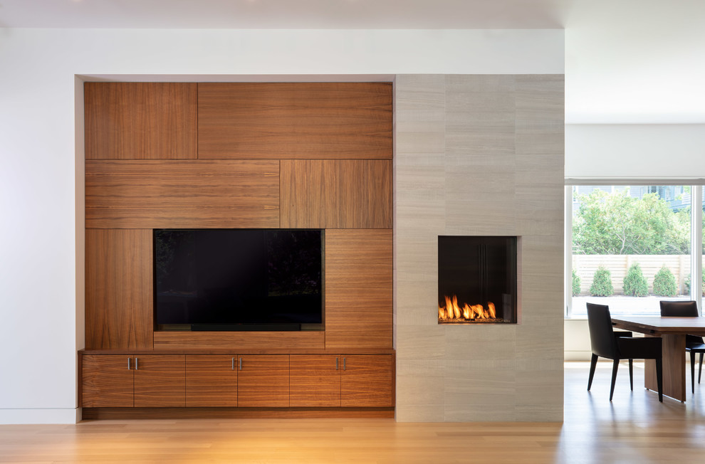 広いコンテンポラリースタイルのおしゃれなLDK (白い壁、淡色無垢フローリング、標準型暖炉、タイルの暖炉まわり、埋込式メディアウォール、ベージュの床) の写真