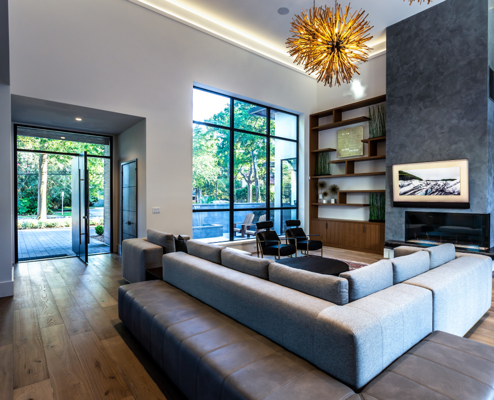 This is an example of an expansive midcentury formal open plan living room in Houston with light hardwood flooring, a two-sided fireplace, a plastered fireplace surround, a wall mounted tv, brown floors and a drop ceiling.