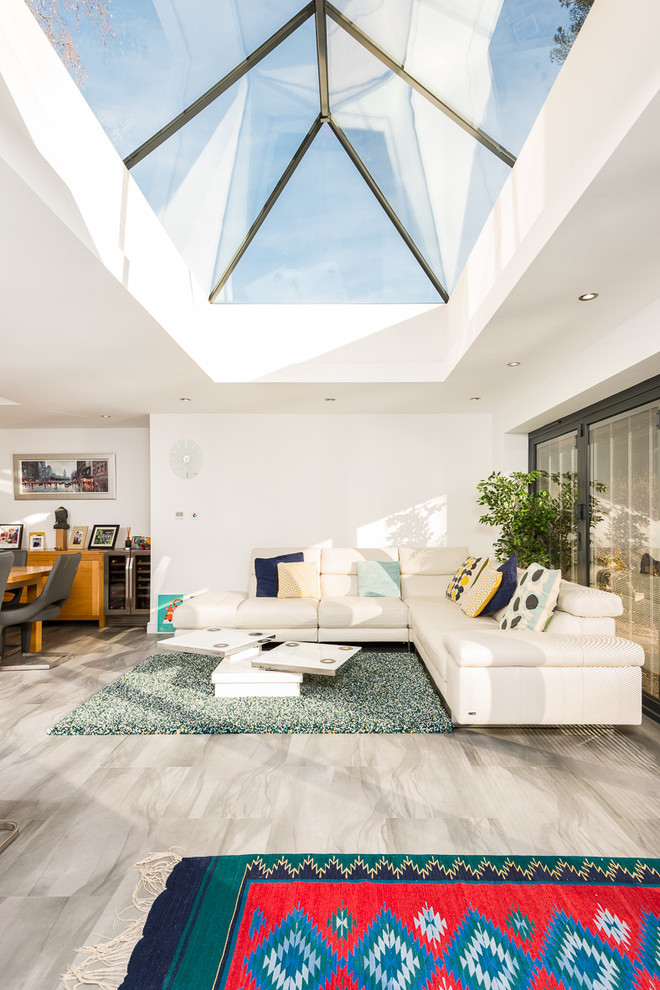 Example of a mid-sized transitional open concept slate floor and gray floor living room design in Hampshire with white walls