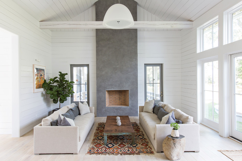 Repräsentatives Skandinavisches Wohnzimmer mit weißer Wandfarbe, hellem Holzboden, Kamin und Kaminumrandung aus Beton in Charleston