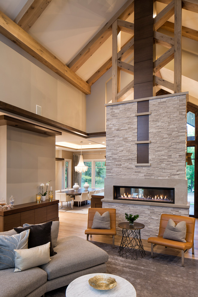 Свежая идея для дизайна: открытая гостиная комната в современном стиле с двусторонним камином и ковром на полу - отличное фото интерьера