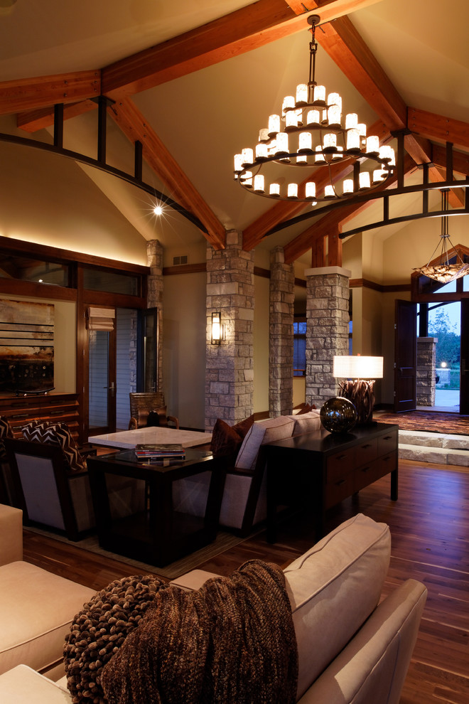 Imagen de salón abierto actual extra grande con paredes beige y suelo de madera en tonos medios