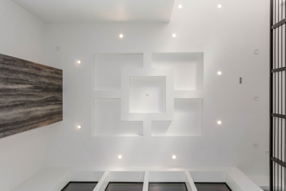 Ejemplo de salón abierto moderno grande con paredes blancas, suelo de madera clara, chimenea lineal, marco de chimenea de baldosas y/o azulejos y suelo gris