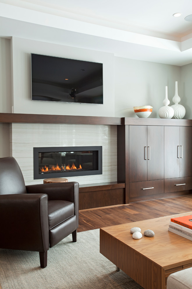 Exempel på ett modernt vardagsrum, med grå väggar, en bred öppen spis och en väggmonterad TV