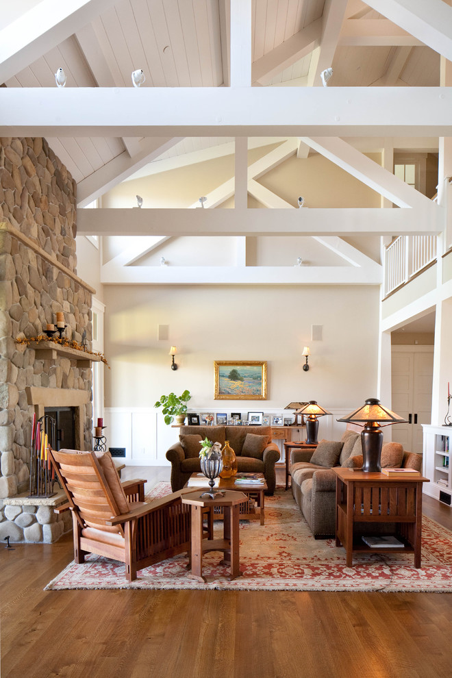 Fernseherloses Landhausstil Wohnzimmer mit braunem Holzboden, Kamin und Kaminumrandung aus Stein in Santa Barbara