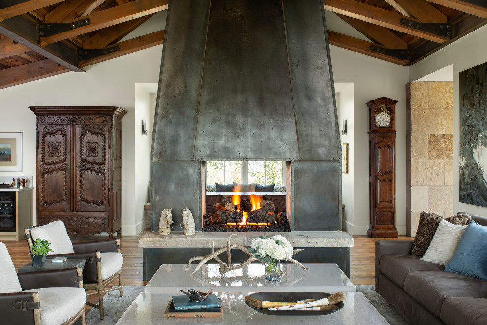 デンバーにある中くらいなコンテンポラリースタイルのおしゃれなLDK (白い壁、淡色無垢フローリング、両方向型暖炉、金属の暖炉まわり、茶色い床) の写真