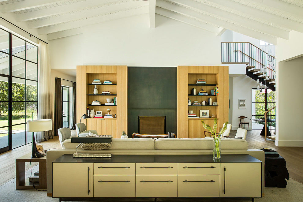 Country Wohnzimmer mit weißer Wandfarbe, braunem Holzboden, Kamin, braunem Boden und verstecktem TV in Los Angeles