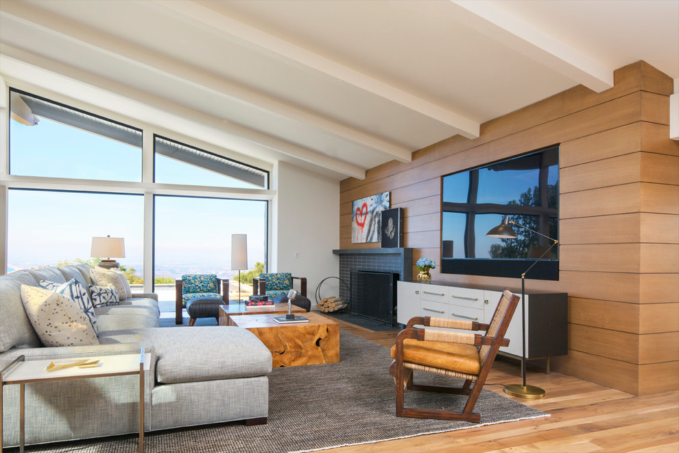 Living room - mid-century modern open concept light wood floor living room idea in Los Angeles with white walls, a standard fireplace, a tile fireplace and a wall-mounted tv