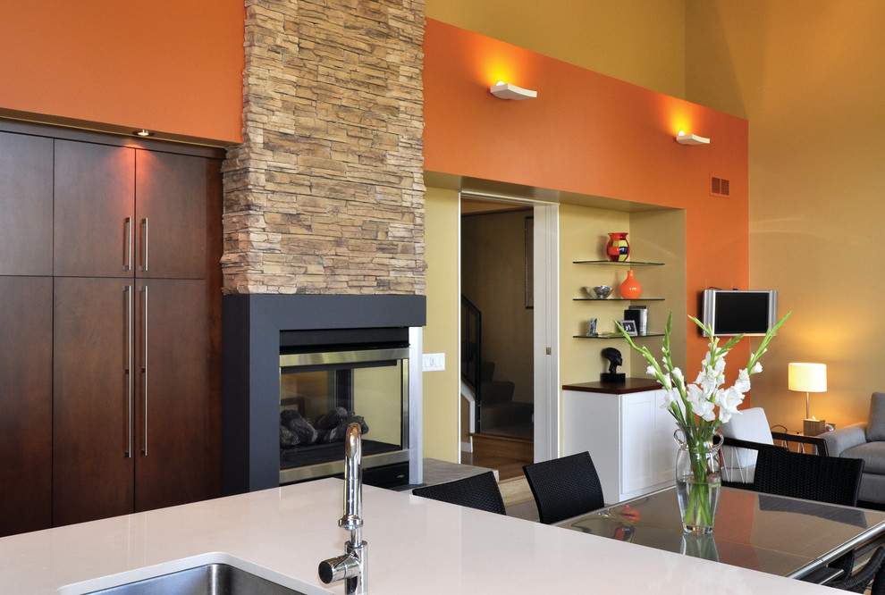 Ejemplo de salón abierto clásico de tamaño medio con parades naranjas, suelo de madera clara, marco de chimenea de piedra y televisor colgado en la pared