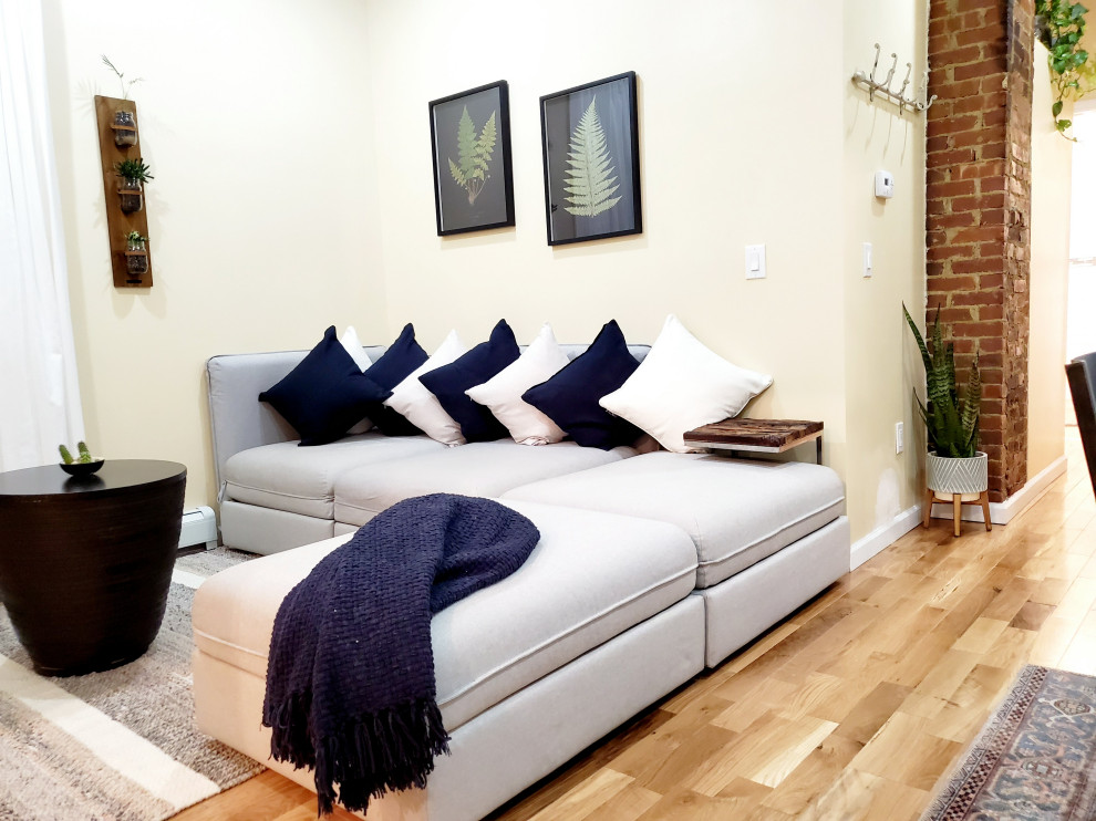 Immagine di un piccolo soggiorno minimalista aperto con TV a parete