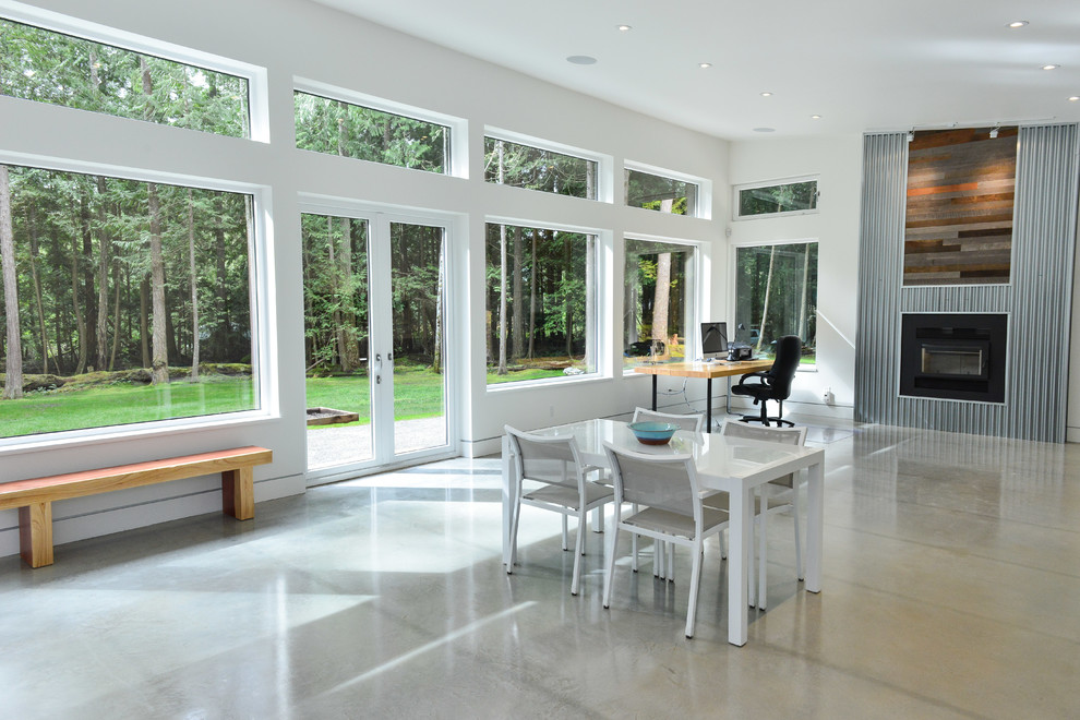 Modernes Wohnzimmer mit Betonboden, Kaminofen, Kaminumrandung aus Holz, grauem Boden und weißer Wandfarbe in Vancouver