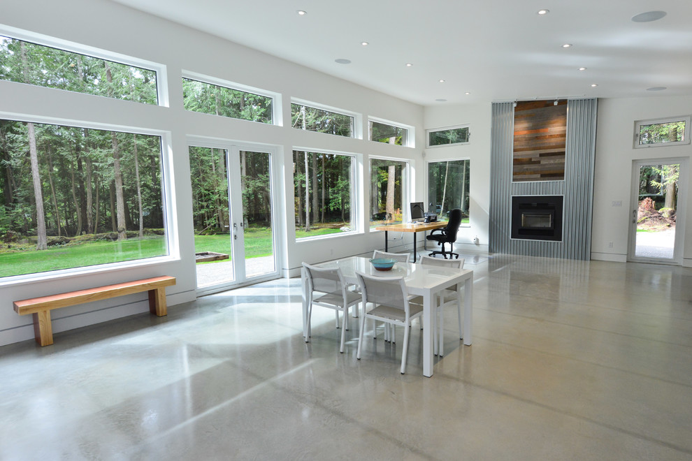 Modernes Wohnzimmer mit Betonboden, Kaminofen, Kaminumrandung aus Holz, grauem Boden und weißer Wandfarbe in Vancouver
