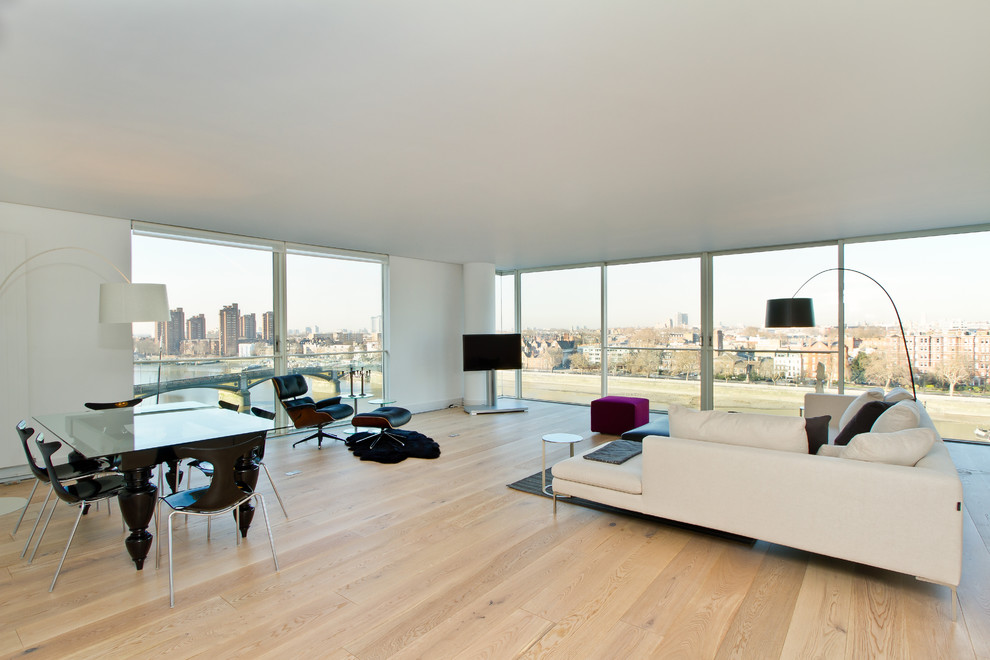 Example of a danish light wood floor living room design in London