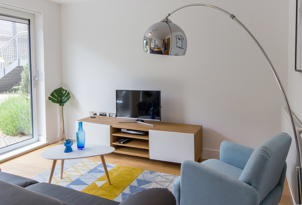 Imagen de salón abierto escandinavo pequeño con paredes blancas, suelo laminado, televisor independiente y suelo marrón