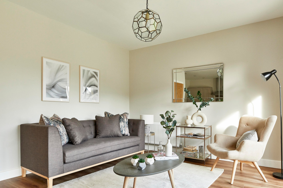 Mittelgroßes, Fernseherloses, Offenes Skandinavisches Wohnzimmer ohne Kamin mit grauer Wandfarbe, Laminat und braunem Boden in Sonstige