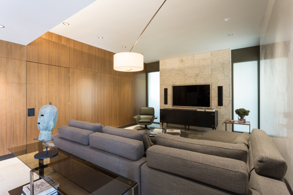 Diseño de salón cerrado moderno de tamaño medio sin chimenea con televisor colgado en la pared, paredes beige, suelo de mármol y piedra