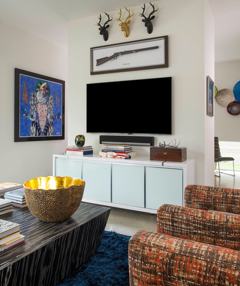 Cette image montre un salon design de taille moyenne et ouvert avec un mur blanc, sol en béton ciré et un téléviseur fixé au mur.