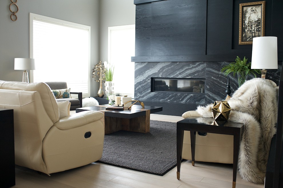 Inspiration pour un grand salon mansardé ou avec mezzanine traditionnel avec un mur gris, parquet clair, une cheminée standard, un manteau de cheminée en pierre et un téléviseur encastré.