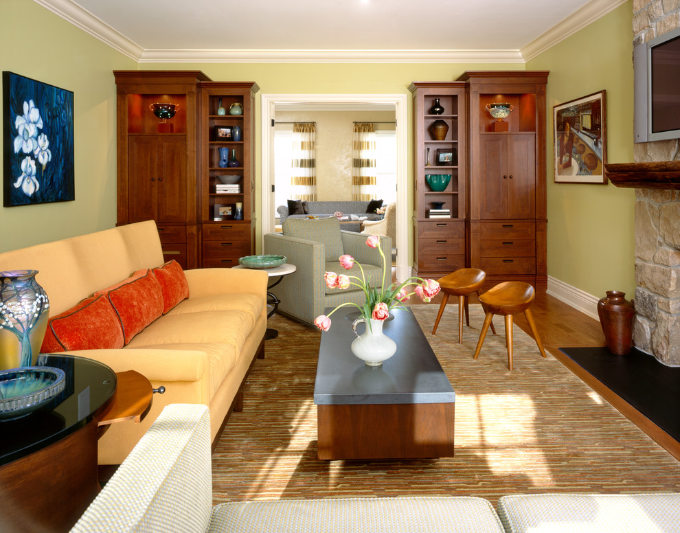 Idee per un soggiorno tradizionale chiuso con sala formale, pareti verdi, pavimento in legno massello medio, cornice del camino in pietra e TV a parete