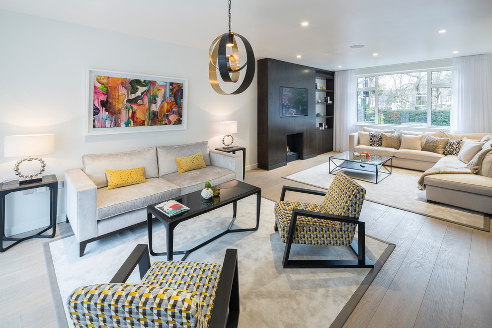 Esempio di un soggiorno design aperto con sala formale, pareti bianche, parquet chiaro, camino classico e TV a parete