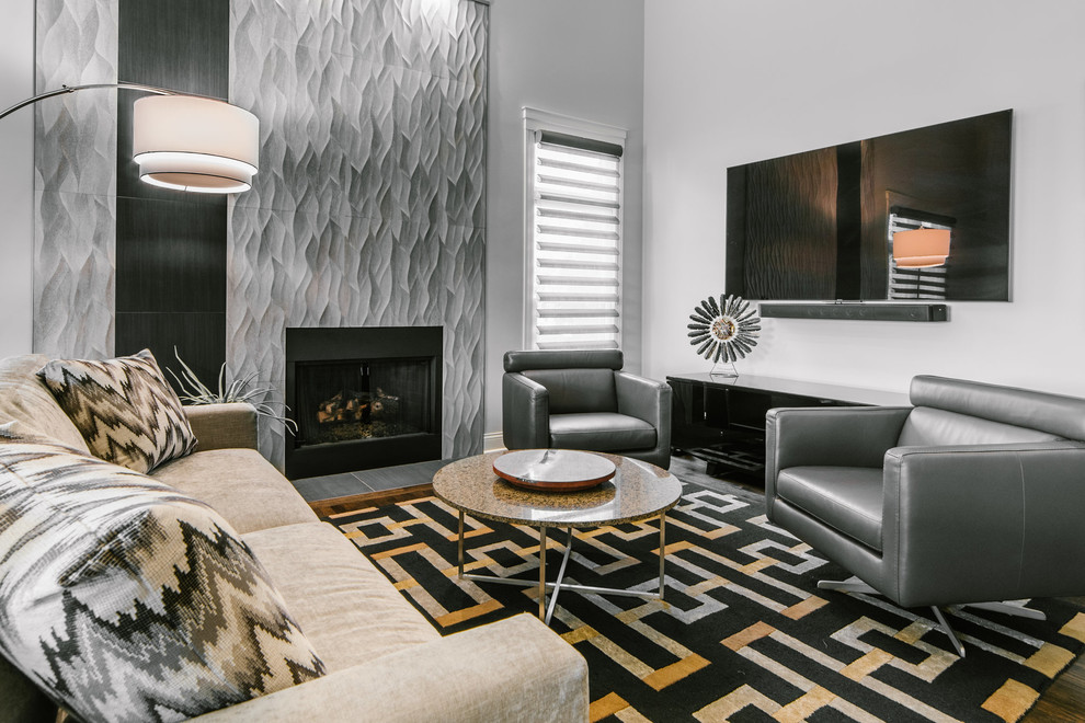 Inspiration for a large contemporary open plan living room in Chicago with grey walls, medium hardwood flooring, a standard fireplace, a tiled fireplace surround, a wall mounted tv, brown floors and a music area.