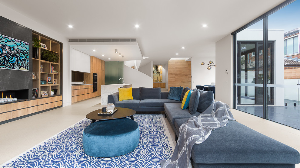 Offenes Modernes Wohnzimmer mit weißer Wandfarbe, Gaskamin und grauem Boden in Melbourne