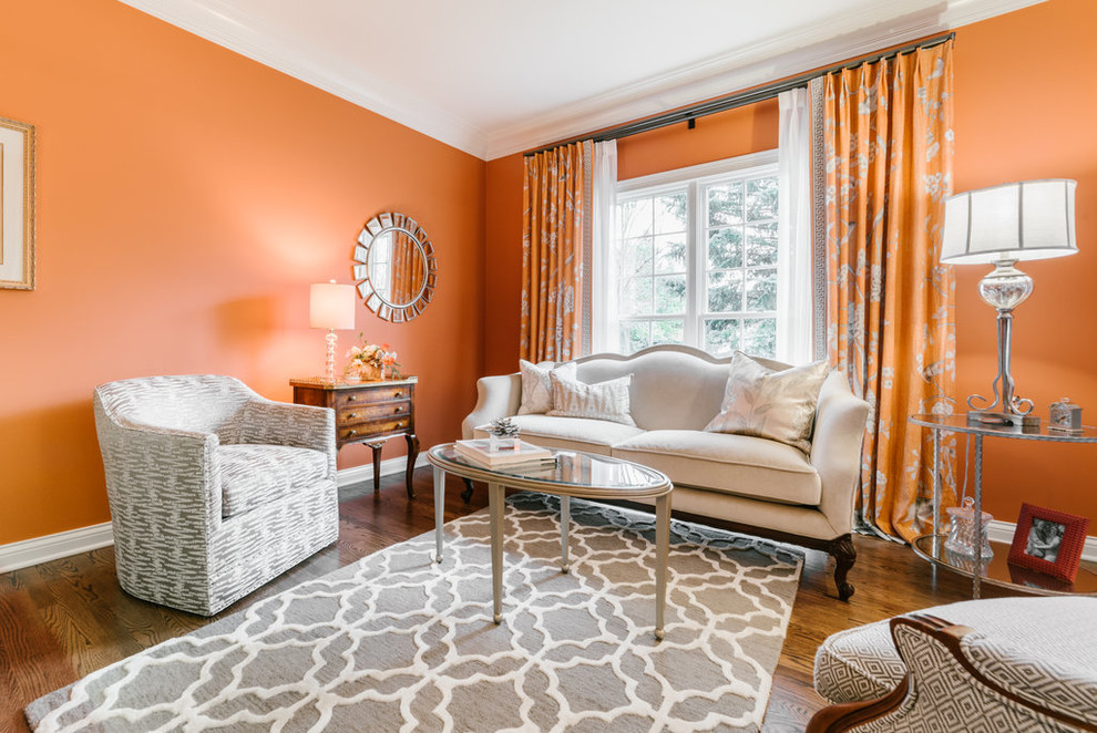 Foto de salón para visitas abierto clásico renovado de tamaño medio sin televisor con parades naranjas, suelo de madera en tonos medios y suelo marrón