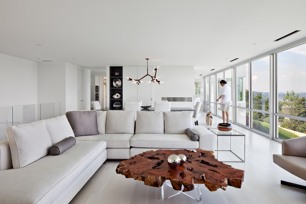 Стильный дизайн: открытая гостиная комната в стиле модернизм с белыми стенами и деревянным полом - последний тренд