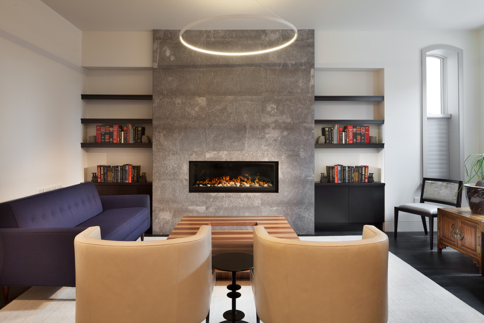 Стильный дизайн: открытая гостиная комната среднего размера в современном стиле с стандартным камином, фасадом камина из камня, белыми стенами, темным паркетным полом, черным полом и синим диваном - последний тренд