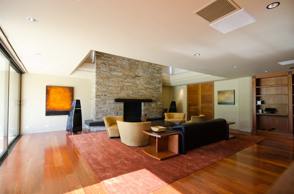 Источник вдохновения для домашнего уюта: парадная гостиная комната в стиле модернизм с светлым паркетным полом, стандартным камином и фасадом камина из камня