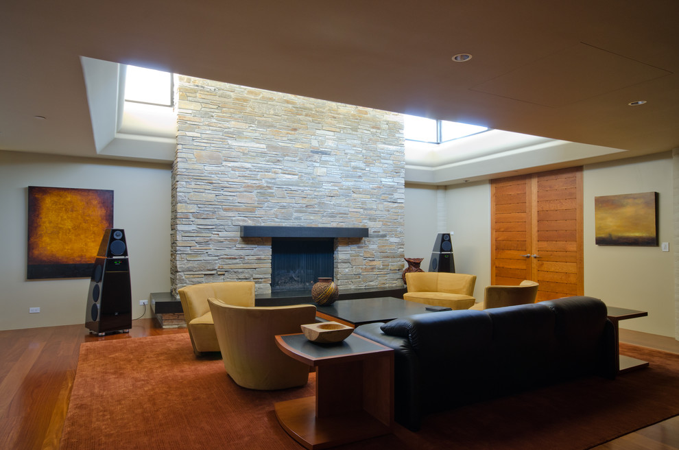 Foto de salón para visitas moderno con suelo de madera clara, todas las chimeneas y marco de chimenea de piedra