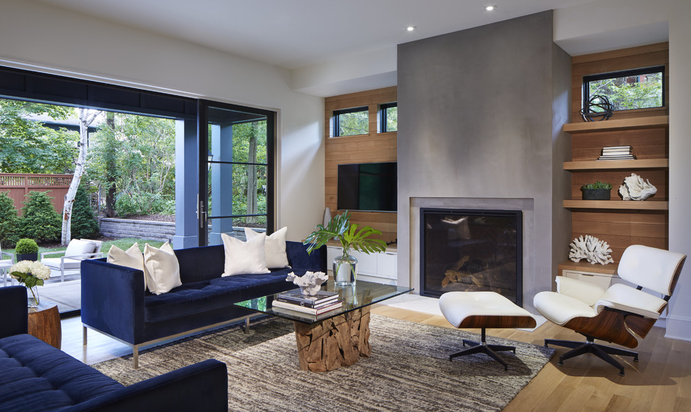 This is an example of a classic open plan living room in Minneapolis with white walls, light hardwood flooring, a standard fireplace, a plastered fireplace surround and a wall mounted tv.