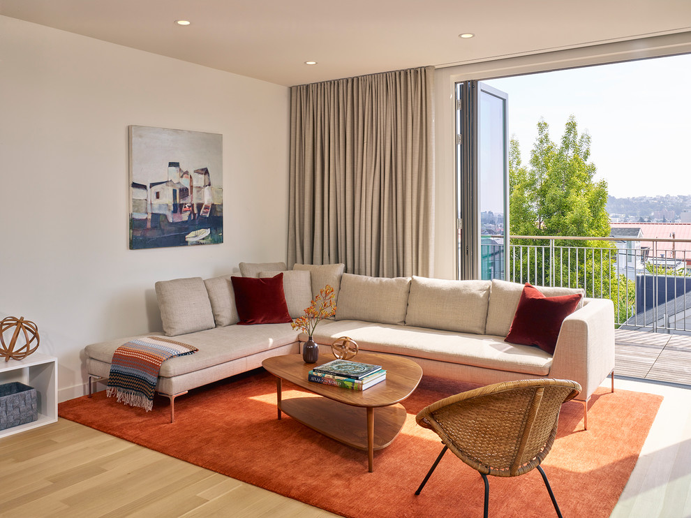 Immagine di un soggiorno minimal di medie dimensioni e aperto con pareti beige, parquet chiaro e pavimento beige