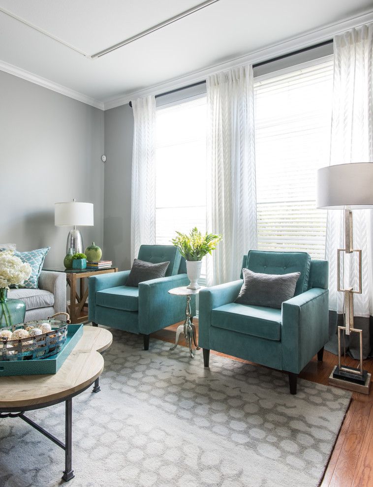 Design ideas for a medium sized modern grey and teal open plan living room in Dallas with grey walls, light hardwood flooring, no fireplace, a freestanding tv and feature lighting.