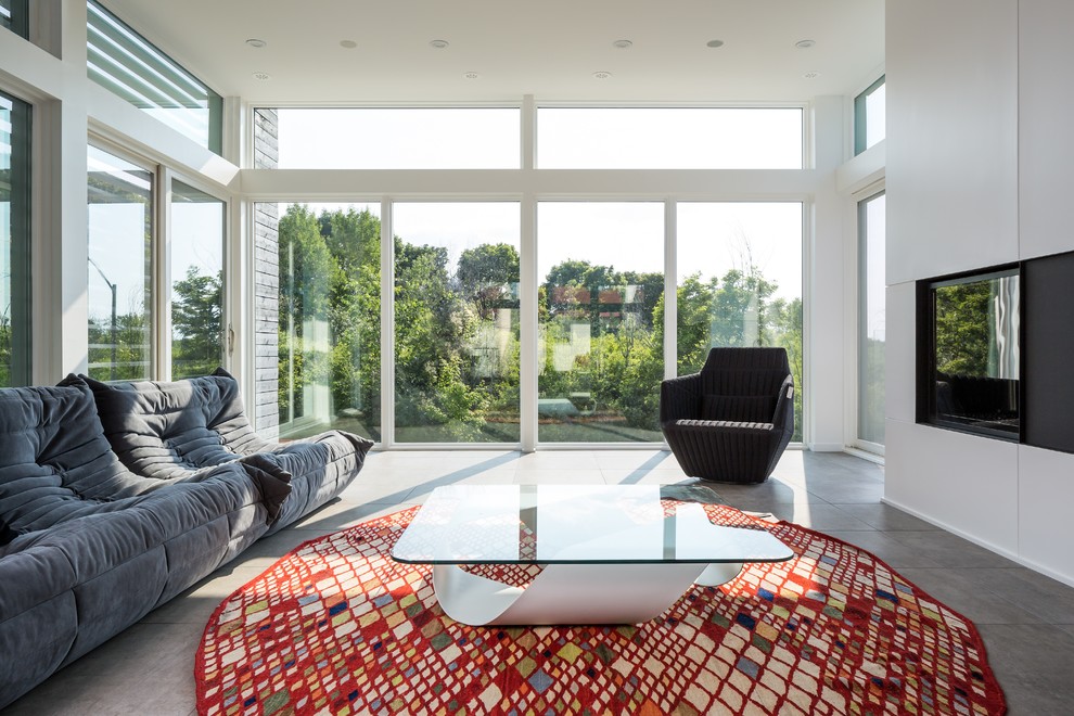 Mittelgroßes, Abgetrenntes Modernes Wohnzimmer ohne Kamin mit weißer Wandfarbe, TV-Wand und Betonboden in Ottawa