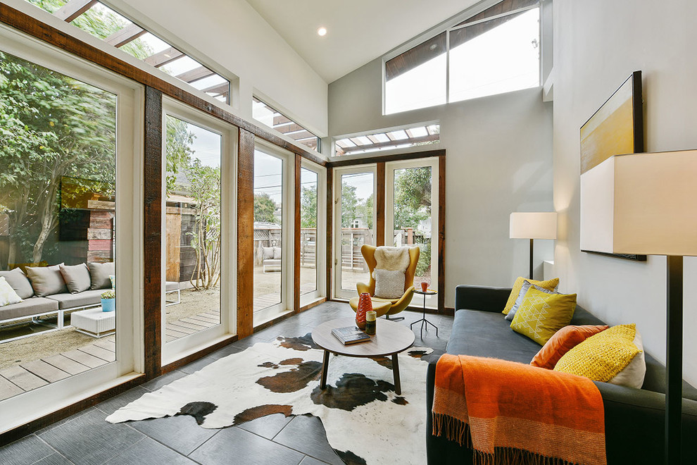 На фото: гостиная комната среднего размера в современном стиле с серыми стенами и полом из керамогранита без камина, телевизора с