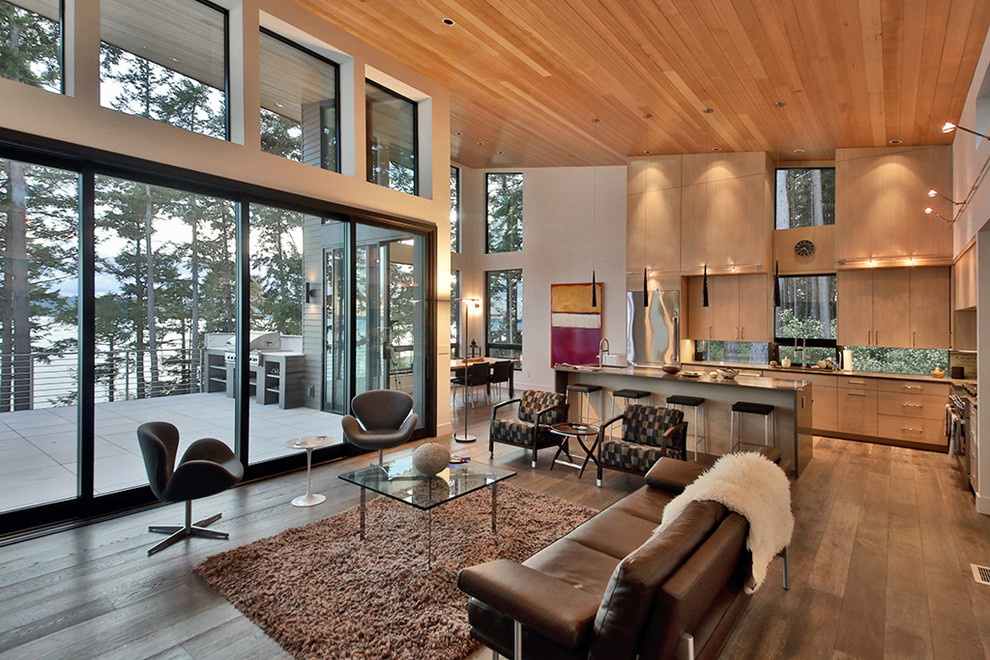 Example of a large minimalist open concept medium tone wood floor and brown floor living room design in Seattle with white walls, a ribbon fireplace, a stone fireplace and a wall-mounted tv