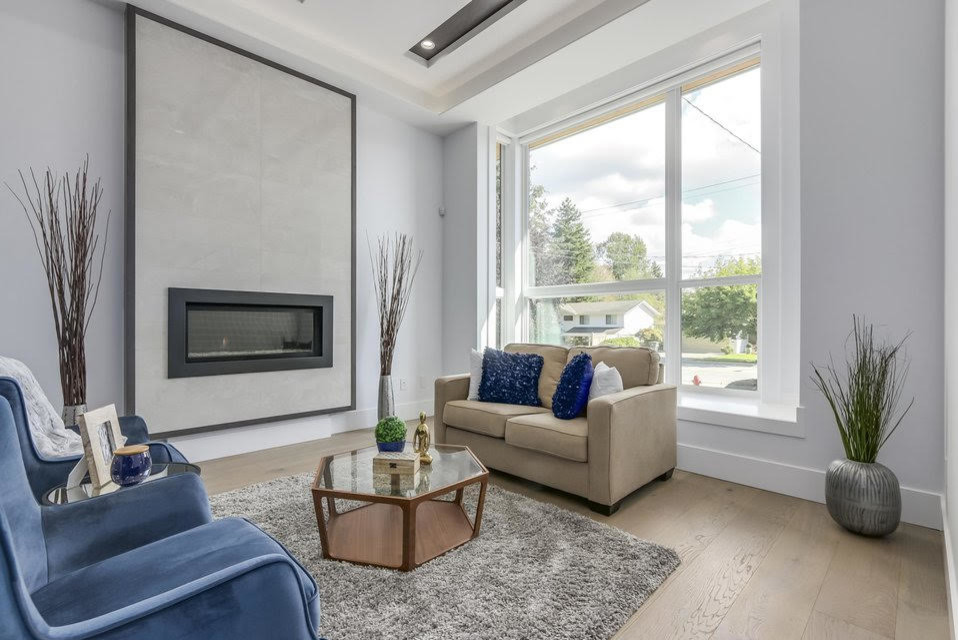 Imagen de salón para visitas moderno pequeño sin televisor con paredes grises, suelo de madera clara, chimenea lineal y suelo beige