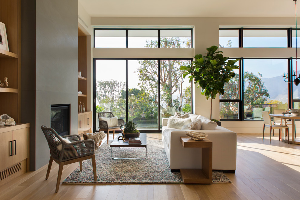 Esempio di un soggiorno minimal con pareti beige, pavimento in legno massello medio e camino classico