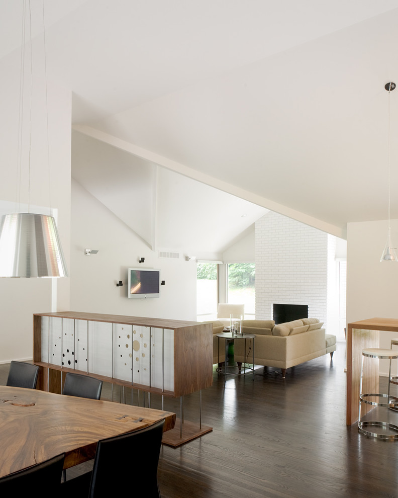 Стильный дизайн: гостиная комната в стиле модернизм с фасадом камина из кирпича - последний тренд